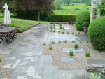 White of Witchampton - landscape gardener - A grey natural stone paving laid in a semi random pattern with gravel and planting.