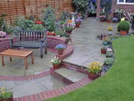 White of Witchampton - landscape gardener - A garden with man-made paving combined with brick edgings and retaining walls.